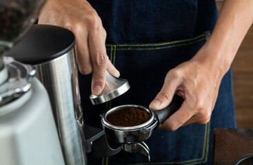 Barista make coffee espresso machine in cafe restaurant. Details of barista making espresso with machine pouring and brewing fresh coffee. Prepares espresso in his coffee shop, fresh hot coffee.