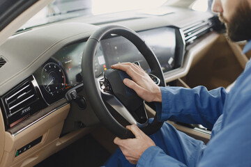 Man driving a black car looks at speedometer