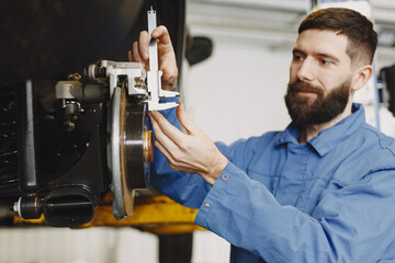 Man replaces wheel in car in garage on hoist