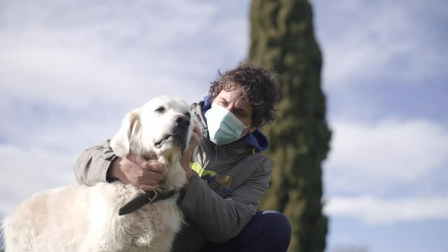 Teenager caressing puppy golden retriever in sunny day