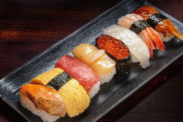 setting of sushi rolls with caviar and chopped fresh fish on background, Asian food, traditional Japanese food