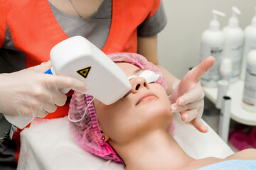 A woman in a beauty salon takes a procedure for laser depilation of the upper lip
