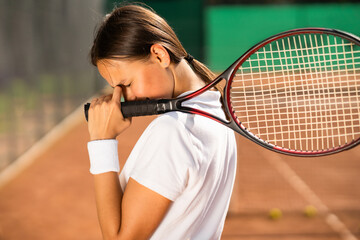 Sad tennis player with racket in hand on the court