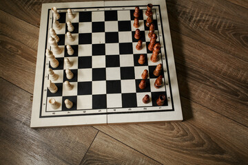 Chess board with chess on a parquet background.