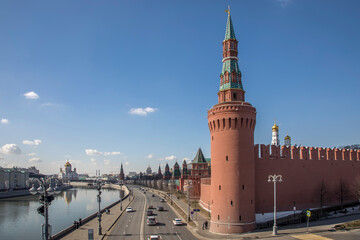 The beautiful Moscow Kremlin on the banks of the river. Red brick towers. Blue sky. Sunny day. Ancient architecture.