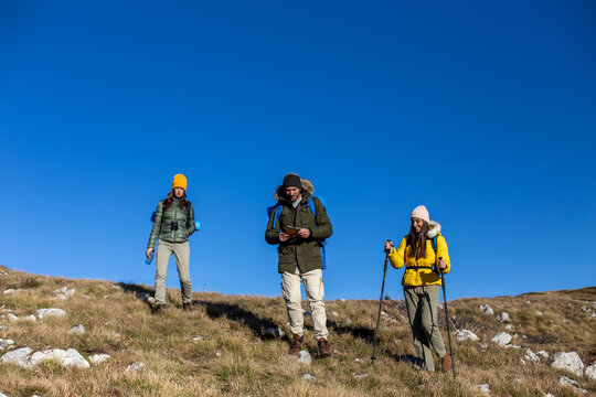 Group of friends haking in the mountains.	