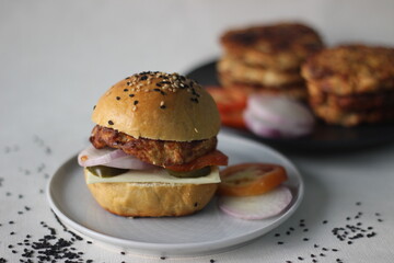 Chicken burger. Prepared by homemade chicken patty, onions, jalapeno and cheese sandwiched inside home baked burger buns