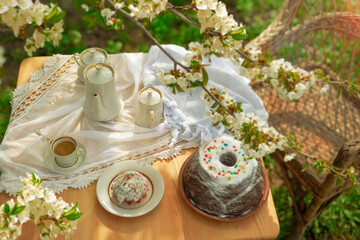 Coffee set on a white tablecloth on a sunny day, cherry blossom, cupcake, pudding. Outdoor, picnic,...
