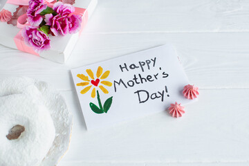 Mother day card on white background. Breakfast, carnation gift and a postcard made by the child for...