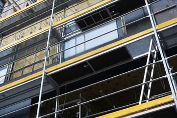 Metal scaffolding at the facade of the building under construction.
