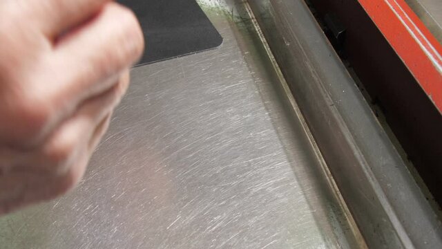 Skilled tailor measures leather slice width with rusty tool