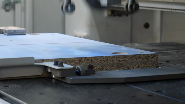 Sawmill machine for cutting MDF parts. Manufacture of elements for furniture. Automated machine tool of industrial equipment in a furniture manufacturing plant close-up
