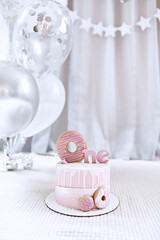 Birthday pink buttercream cake, decorated with meringue cookies for first birthday. 