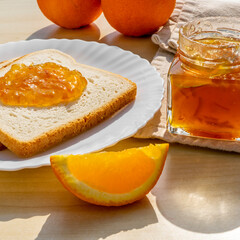 Slices of bread toast with homemade orange jam for breakfast on a wooden background. Breakfast...