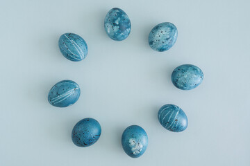 Minimalistic Easter flat lay of Easter eggs laid out in a circle on a light blue background with space for text, top view. Easter is coming soon. Spring Festival