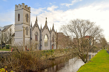 River Corrid passing through the beautiful city of Galway with a church and historic buildings on its left bank, Galway, Ireland
