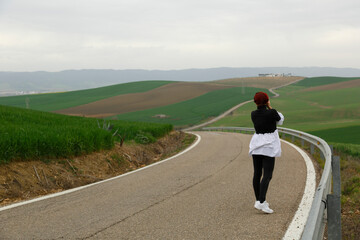  Mujer tomando fotos divertida en la carretera de curvas en Andalucía