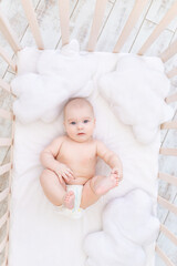 baby boy in the crib in the nursery, cute funny little baby six months, healthy sleep concept