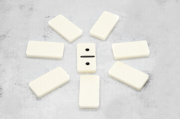 Pieces of dominoes are arranged in a circle in the center of dominoes with two ones. Logic board games symbol. Selective focus, blurred background.