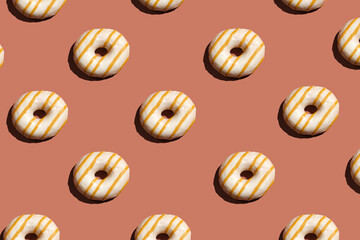 Glazed doughnuts texture. Donuts on brown background. Sweet unhealthy food concept.