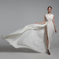 Fashion woman portrait in white long flying airy dress
