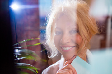 attractive middle age woman with perfect smile put stickers at glass