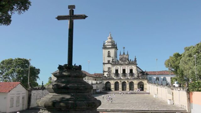 03 CRUCIFIX IN FRONT OF THE CHURCH OF SAO FRANCISCO IN THE CITY OF JOAO PESSOA IN PARAIBA BRAZIL WITH CHILDREN WALKING IN THE COURTYARD