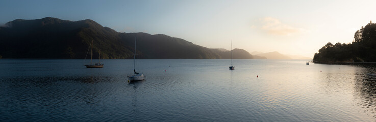 Fototapeta na wymiar Calm lake at sunrise with boats