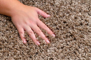 Close up of hand touching soft carpet. Gentle and fluffy carpet between fingers.