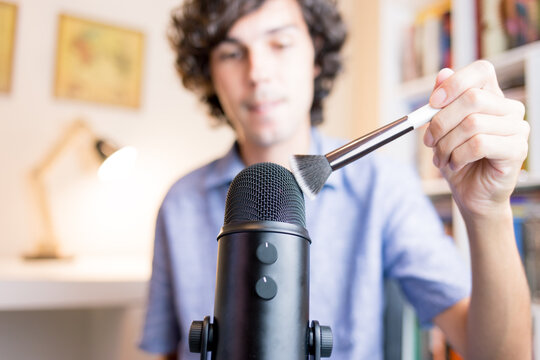 Brush touching the microphone. Young making ASMR sounds with the movement of a makeup brush. Concept of recording sounds to relieve stress.