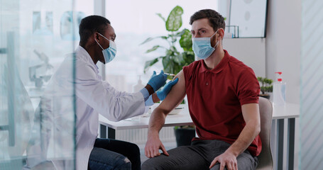 Coronavirus vaccination. Young afro-american doctor general practitioner worker injecting medical...