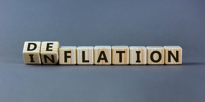 Inflation or deflation symbol. Turned cubes and changed the word inflation to deflation. Beautiful grey background, copy space. Business, inflation or deflation concept.