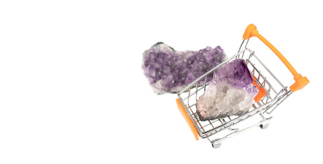 Two raw natural purple amethysts crystals isolated on white background with shopping cart. Banner...