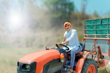 
Indian Asian farmer with tractor preparing land for sowing with cultivator, An Indian farming scene