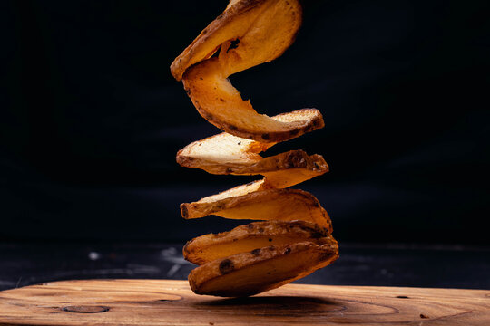 Fried Potato Spiral Tubercle On Wooden Base And Dark Background