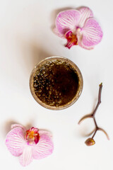 Plate of scrub wiht roses on white orcgids, top view. image of homemade cosmetics ingredients. aroma theme. organic cosmetics.