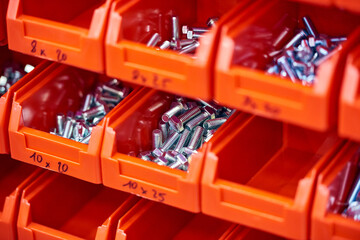 Bolts in a plastic box. Fastening element.