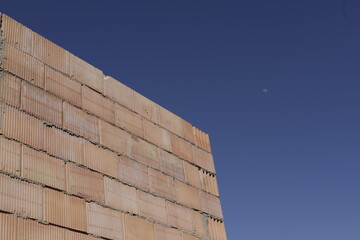 unfrizzled brick wall with blue sky and daytime moon