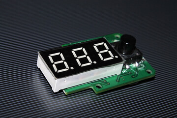 Programmable microcontroller with three-character dial and toggle button.