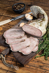 Sliced boiled beef tongue with herbs. Wooden background. Top view