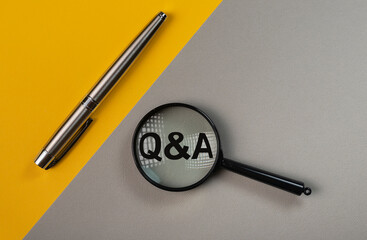 Q or qa concept through magnifying glass on yellow and gray colored background