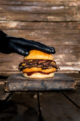 hand smashing onion and bacon hamburger