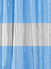 The flag of Argentina on dry wooden surface, cracked with age. Vertical background, wallpaper or...