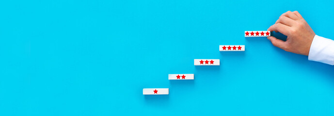 Hand arranging wooden blocks with feedback quality stars. Concept of satisfaction, quality and performance of services.
Copy space for web banner.