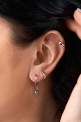 Deer stud earring on woman's ear close up. Piercing