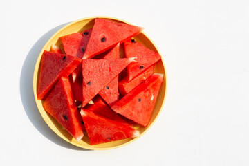 Fresh watermelon slices in yellow plate on white
