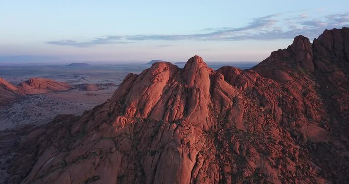 4K sunrise aerial footage of savanna, famous red granite Spitzkoppe Peak and Pontok Mountains in central Namibia between interior town Usakos and Atlantic west coast, southern Africa