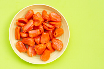 Ripe red Jackfruit on green background.