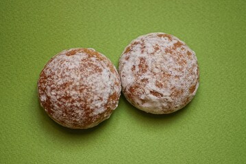 food from two round brown gingerbreads lie on a green table