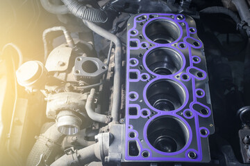 Cylinder head gasket replacement. Repair of a turbocharged diesel engine in a car workshop.